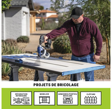 Un homme peint une porte avec un pulvérisateur de peinture à l'extérieur. Projets de bricolage.