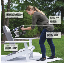 Une femme peint une chaise avec un pistolet à peinture