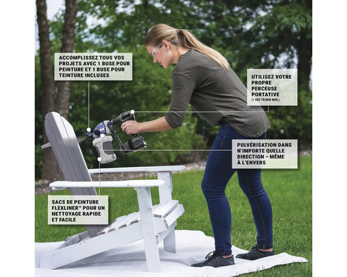 Une femme peint une chaise avec un pistolet à peinture