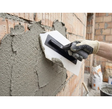 Verputzen einer Ziegelwand mit einer Glättkelle