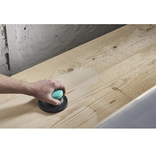 Ponceuse manuelle en cours d'utilisation sur une planche de bois