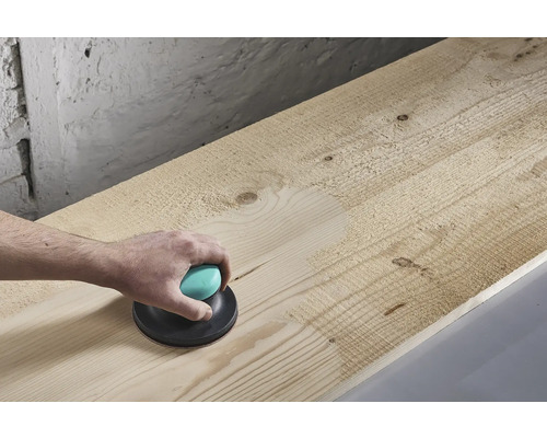 Ponceuse manuelle en cours d'utilisation sur une planche de bois