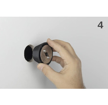 Une main tient le foret à bouchons Wolfcraft devant un trou de forage.