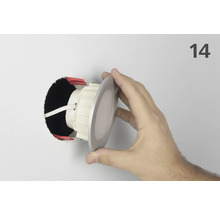 Installation d'un spot encastrable au plafond dans un trou avec la main