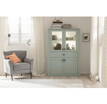 Salon lumineux avec vitrine vert menthe, fauteuil et décoration