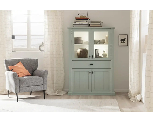 Salon lumineux avec vitrine vert menthe, fauteuil et décoration