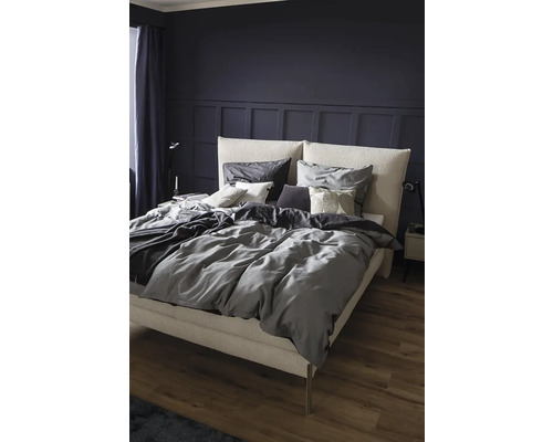 Chambre avec lit double, linge de lit gris et table de chevet