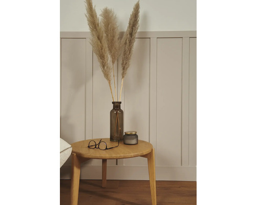 Arrangement décoratif avec de l'herbe de pampa dans un vase, une bougie et des lunettes sur une table en bois