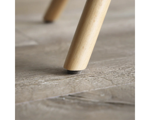 Nahaufnahme eines Möbelbeins aus Holz mit Bodenschoner.