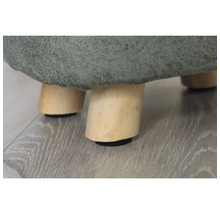 Detailaufnahme eines Hockers mit Holzbeinen