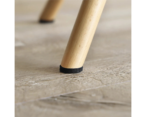 Nahaufnahme eines Stuhlbeins mit Filzgleiter zum Schutz des Bodens