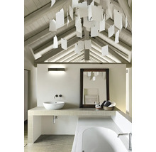 Salle de bains avec lavabo, miroir, baignoire et éclairage décoratif sous un toit mansardé