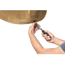 Mains utilisant un outil pour insérer un bouchon dans un récupérateur d'eau de pluie aspect bois de la marque Garantia.