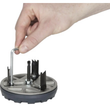 Une main manipule une scie à trou avec une clé Allen