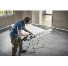 Artisan coupant une porte avec une scie circulaire sur un établi.