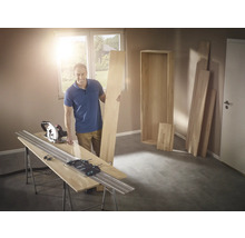 Homme avec scie circulaire et rail de guidage coupant du bois pour une étagère