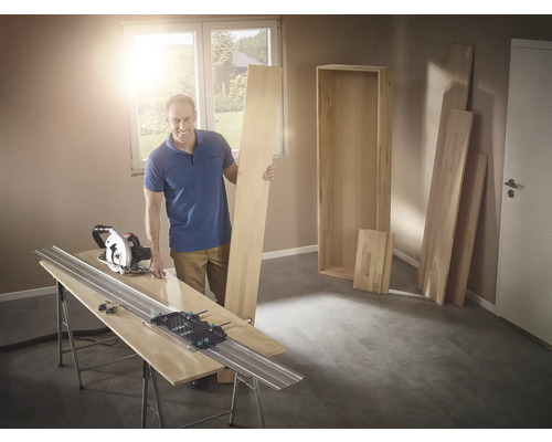 Homme avec scie circulaire et rail de guidage coupant du bois pour une étagère