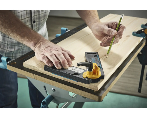 Une personne utilise un gabarit de traçage et un crayon sur une planche en bois.