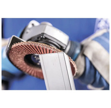 Un homme utilise une meule à lamelles sur une pièce métallique.