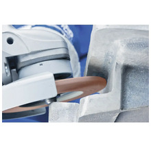 Une meule à tronçonner sur une meuleuse travaille une pièce.