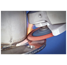 Une meuleuse lisse une surface métallique et produit des étincelles.