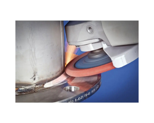 Une meuleuse lisse une surface métallique et produit des étincelles.