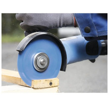 Une personne scie une planche de bois avec une meuleuse d'angle.