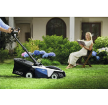 Szene mit Rasenmäher in Betrieb und entspannter Frau im Garten