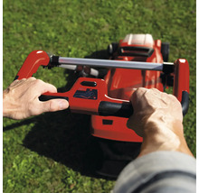 Une personne utilise une tondeuse à gazon sur une pelouse.