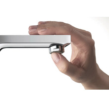 Eine Hand berührt den Strahlregler einer Armatur.