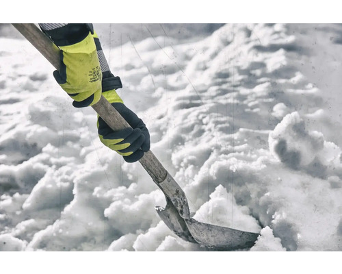Une personne pelletant la neige avec une pelle à neige et des gants