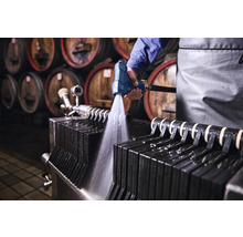 Reinigung eines Plattenfilters mit einer Spritzpistole in einer Weinkellerei.