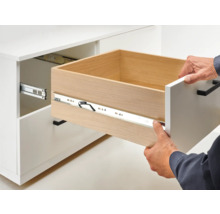 Tiroir ouvert sur une armoire blanche avec coulisses de tiroir