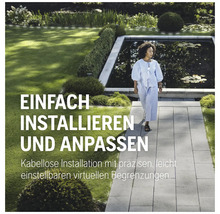 Une femme marche dans un jardin avec un étang sur un chemin de pierre.