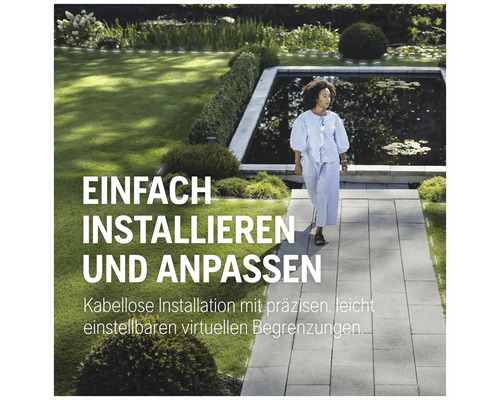 Une femme marche dans un jardin avec un étang sur un chemin de pierre.