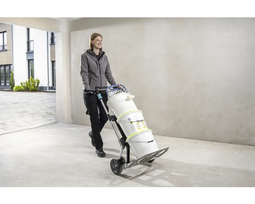 Frau transportiert Farbeimer mit einem Sackkarren.