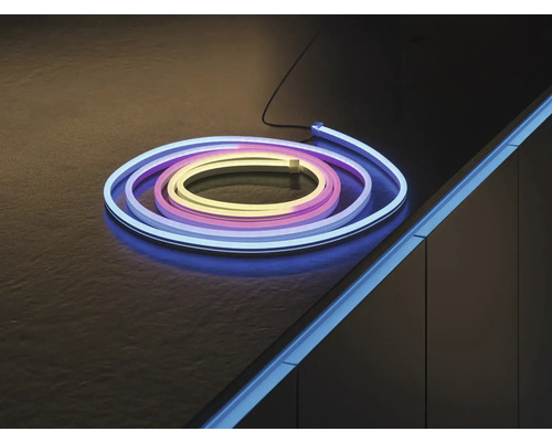 Ruban LED néon flexible, enroulé sur une surface sombre et monté comme éclairage d'accentuation sur le bord d'un meuble.