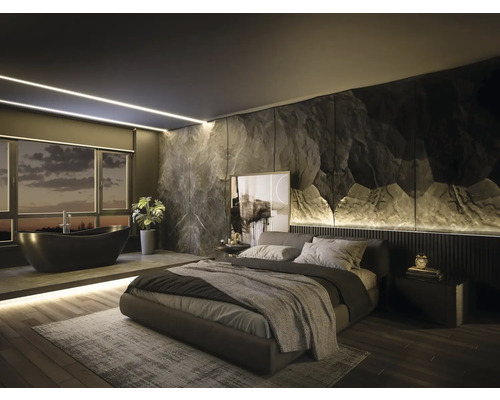Chambre à coucher moderne avec salle de bains intégrée, mur d accent aspect pierre, baignoire îlot noire et lit rembourré sur parquet.