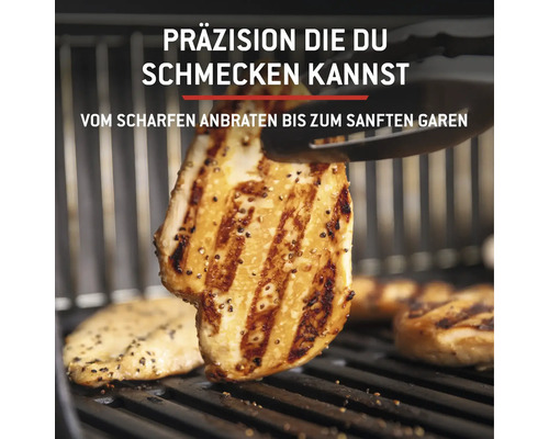 Des filets de poulet grillés sur une grille sont retournés avec une pince de barbecue.