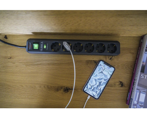 Mehrfachsteckdose mit Überspannungsschutz und einem angeschlossenen Smartphone