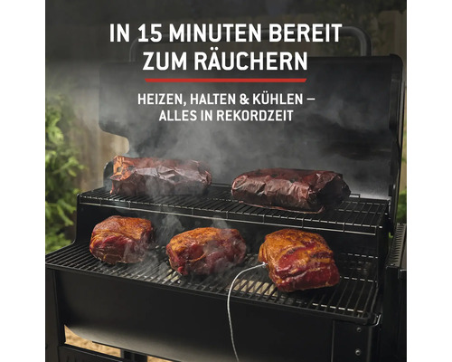 Fleischstücke werden in einem schwarzen Räucherofen zubereitet.