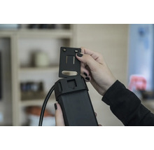 Une personne fixe un support sur un appareil électronique.