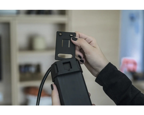 Une personne fixe un support sur un appareil électronique.