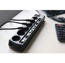 Multiprise noire avec interrupteurs et câbles branchés sur une table