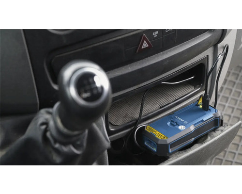 Appareil de localisation Bosch dans le compartiment de rangement d'un véhicule avec câble de charge connecté