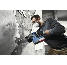 Un homme retire des carreaux avec un marteau perforateur Bosch.