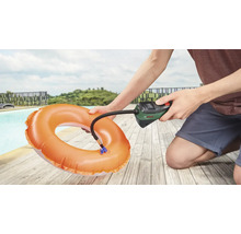 Une personne gonfle une bouée avec une pompe à air Bosch à côté d'une piscine.