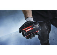 Eine Hand mit Handschuh hält einen 18 Volt Akku