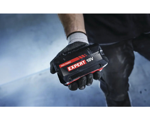 Eine Hand mit Handschuh hält einen 18 Volt Akku