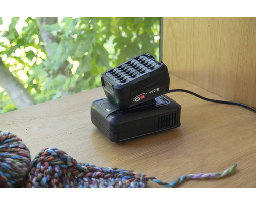 Bloc-batterie et chargeur pour outils électriques sur une table.